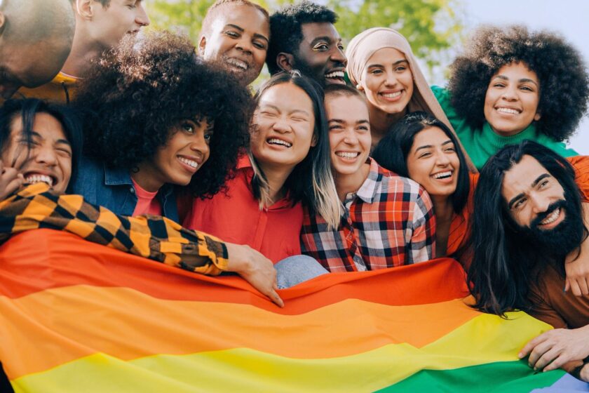 group of lgbtq+ friends holding a pride flag