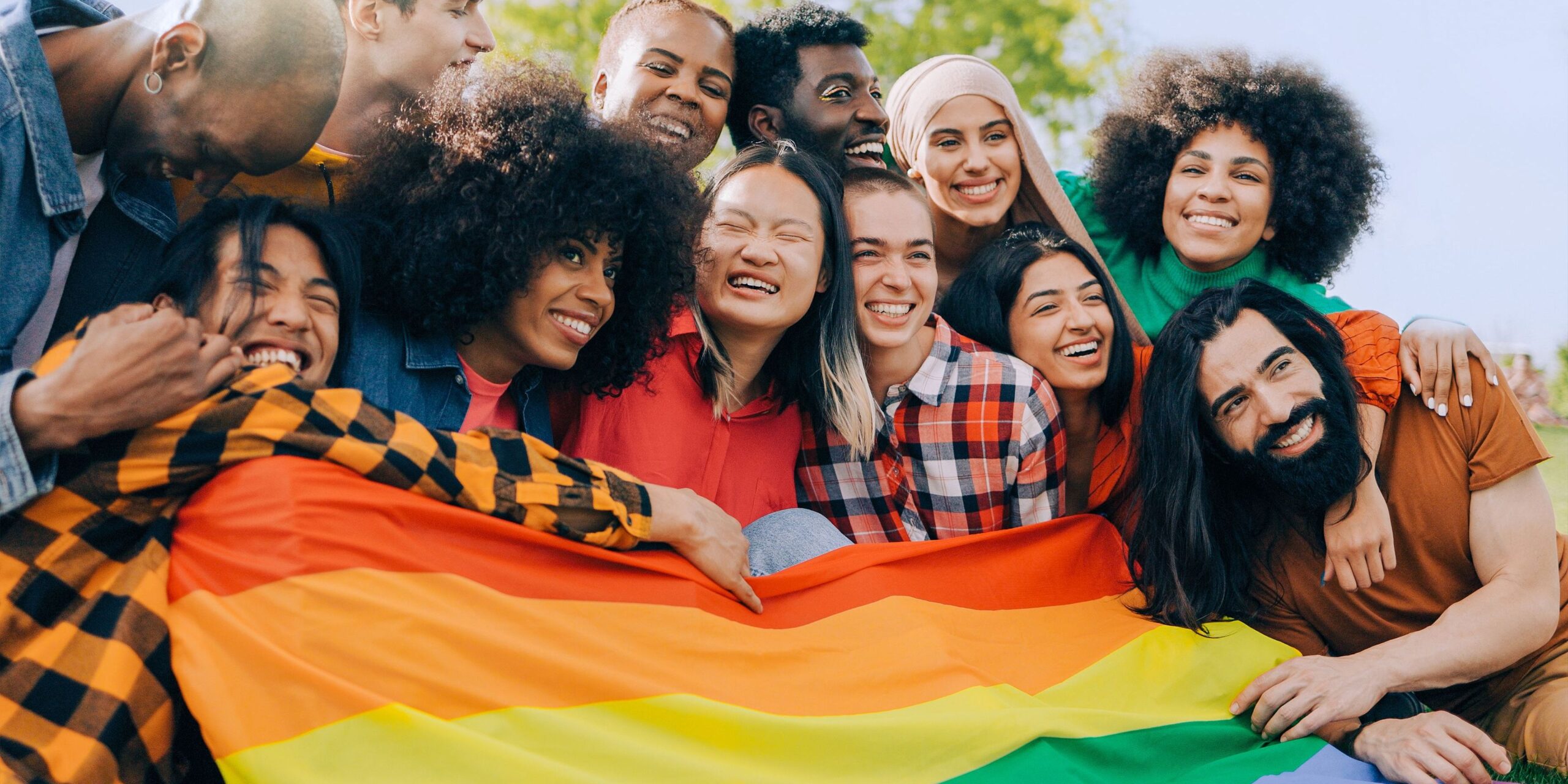group of lgbtq+ friends holding a pride flag