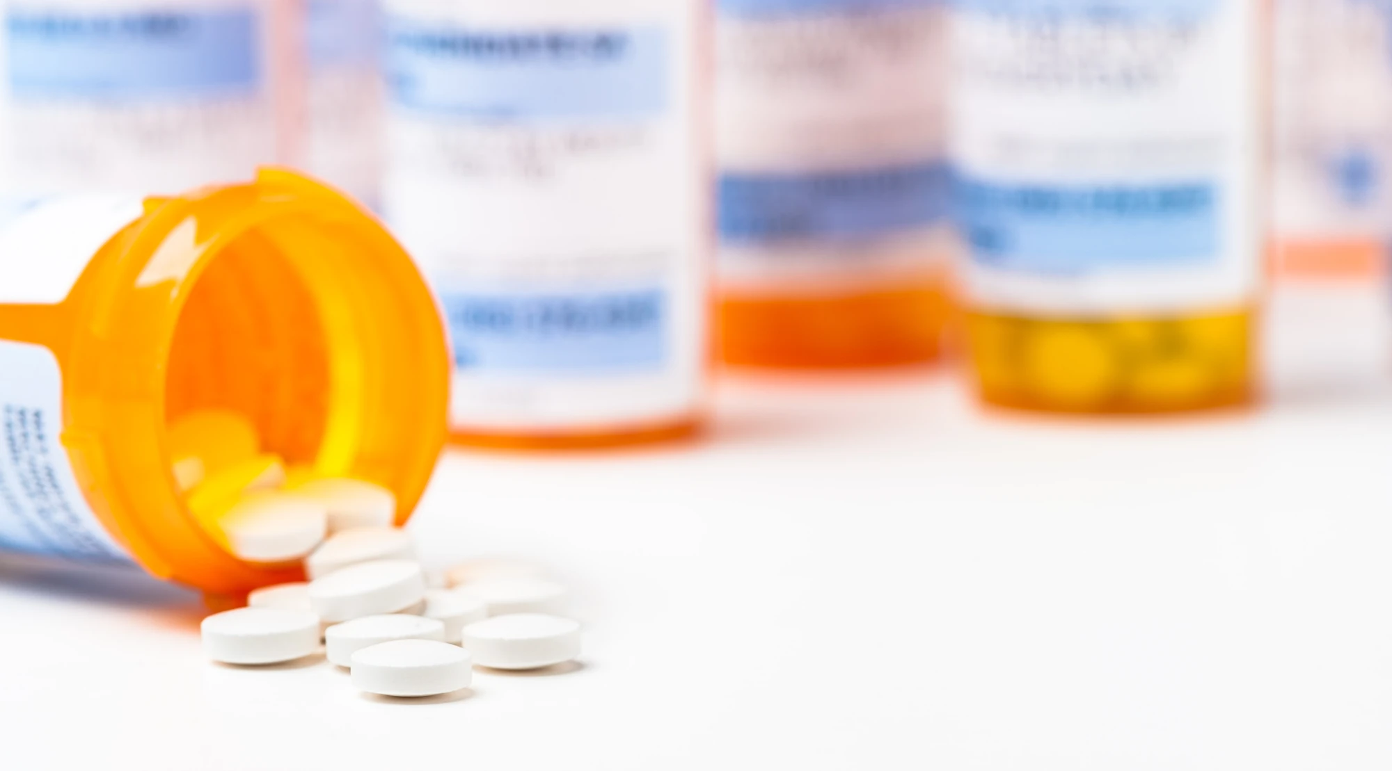 Olanzapine prescription bottle and tablets on a table.