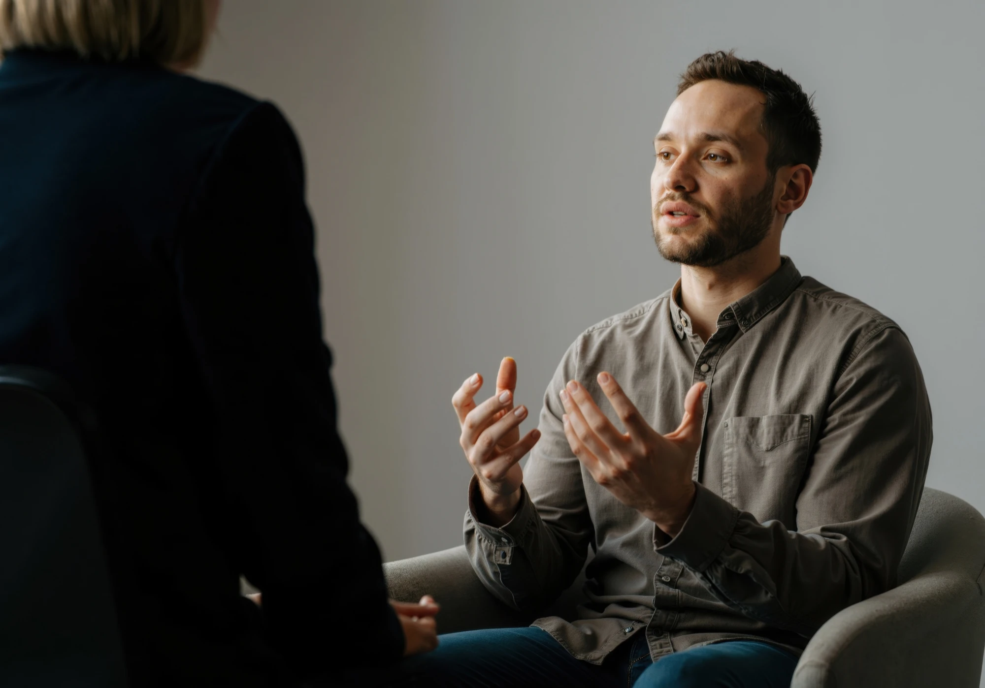 Man sitting in an armchair talking with a therapist