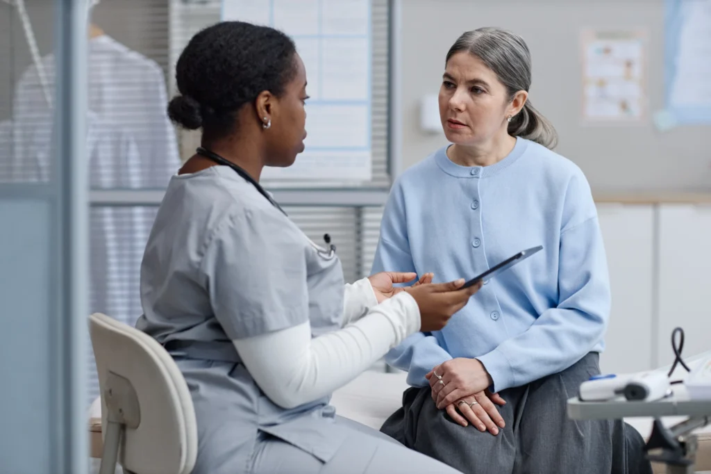 Doctor holding a clipboard and talking with a patient